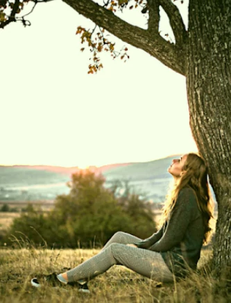 Femme assise sous un arbre en méditation